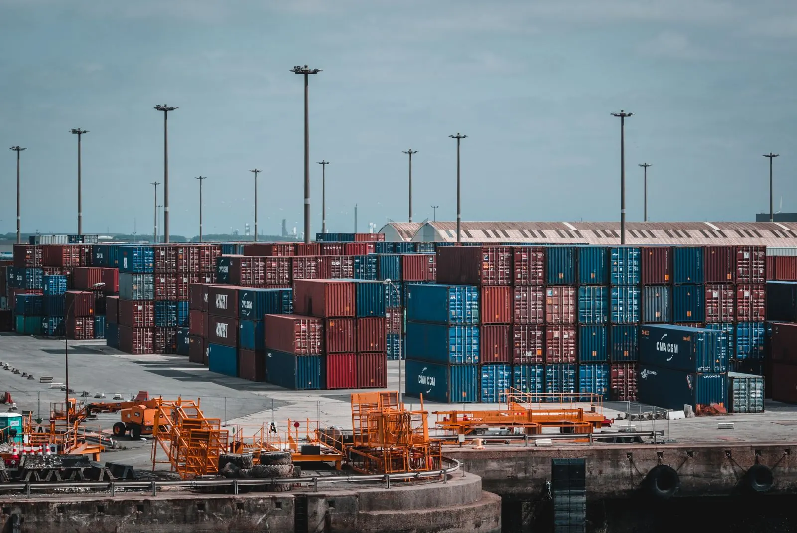 Illustrative photograph: Shipping containers stacked across a port yard.